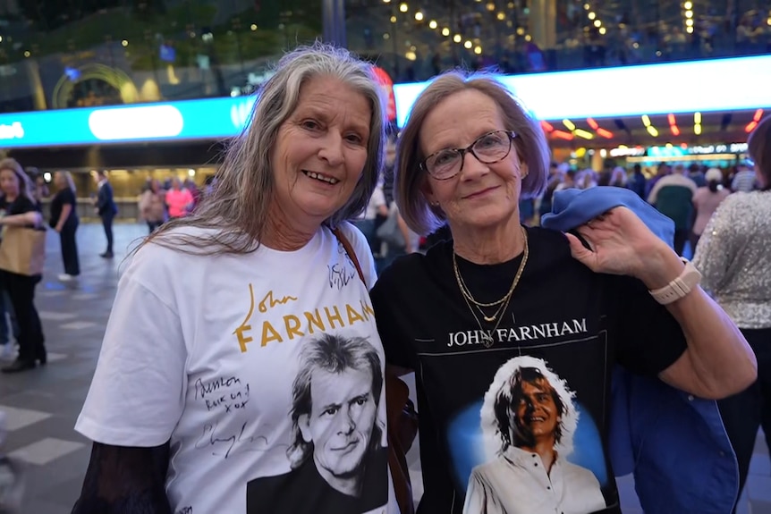 Two women in John Farnham shirts.