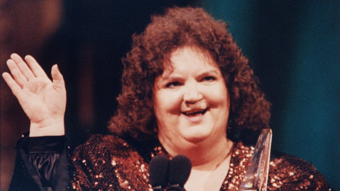 Woman wearing a sequin top waves