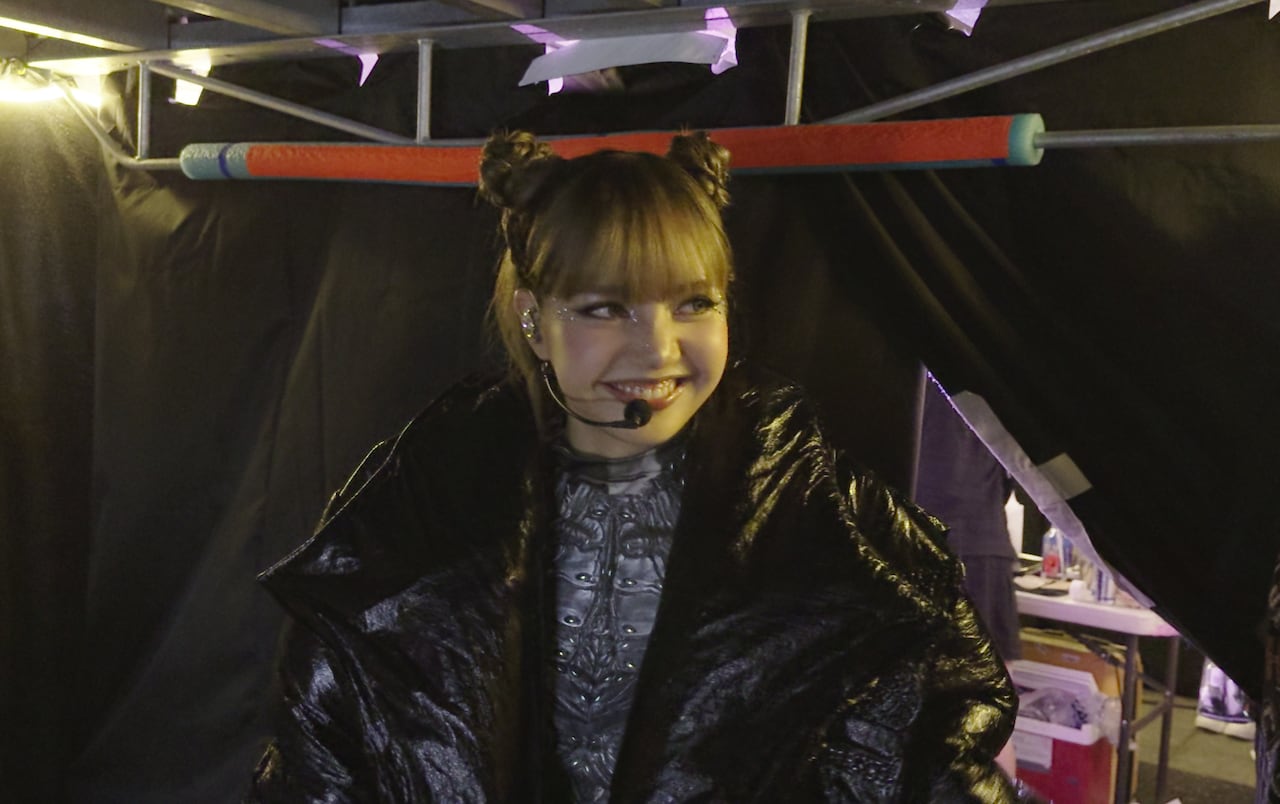 A Korean K-pop idol wears a head microphone and smiles.