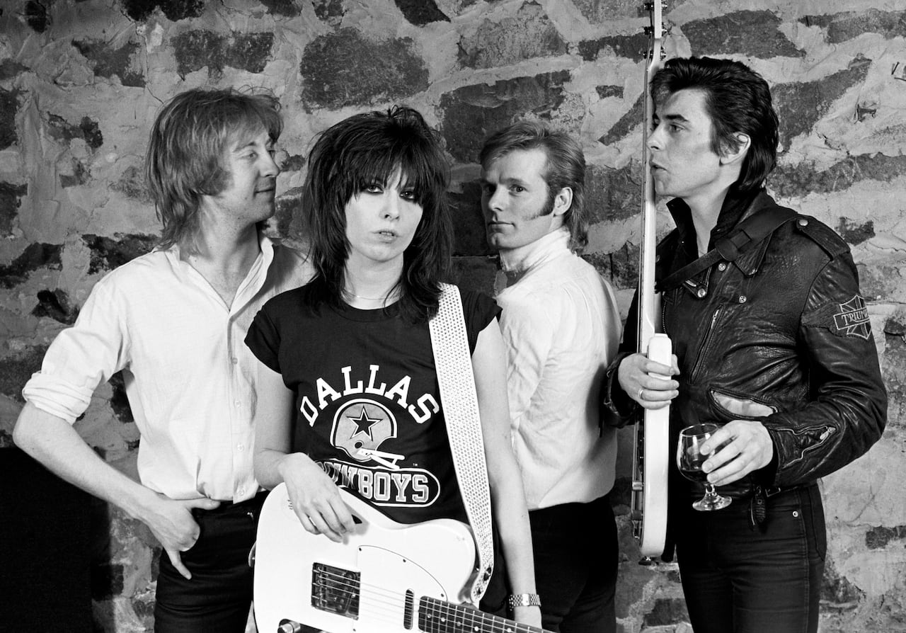 Four musicians posing in a black and white photo.