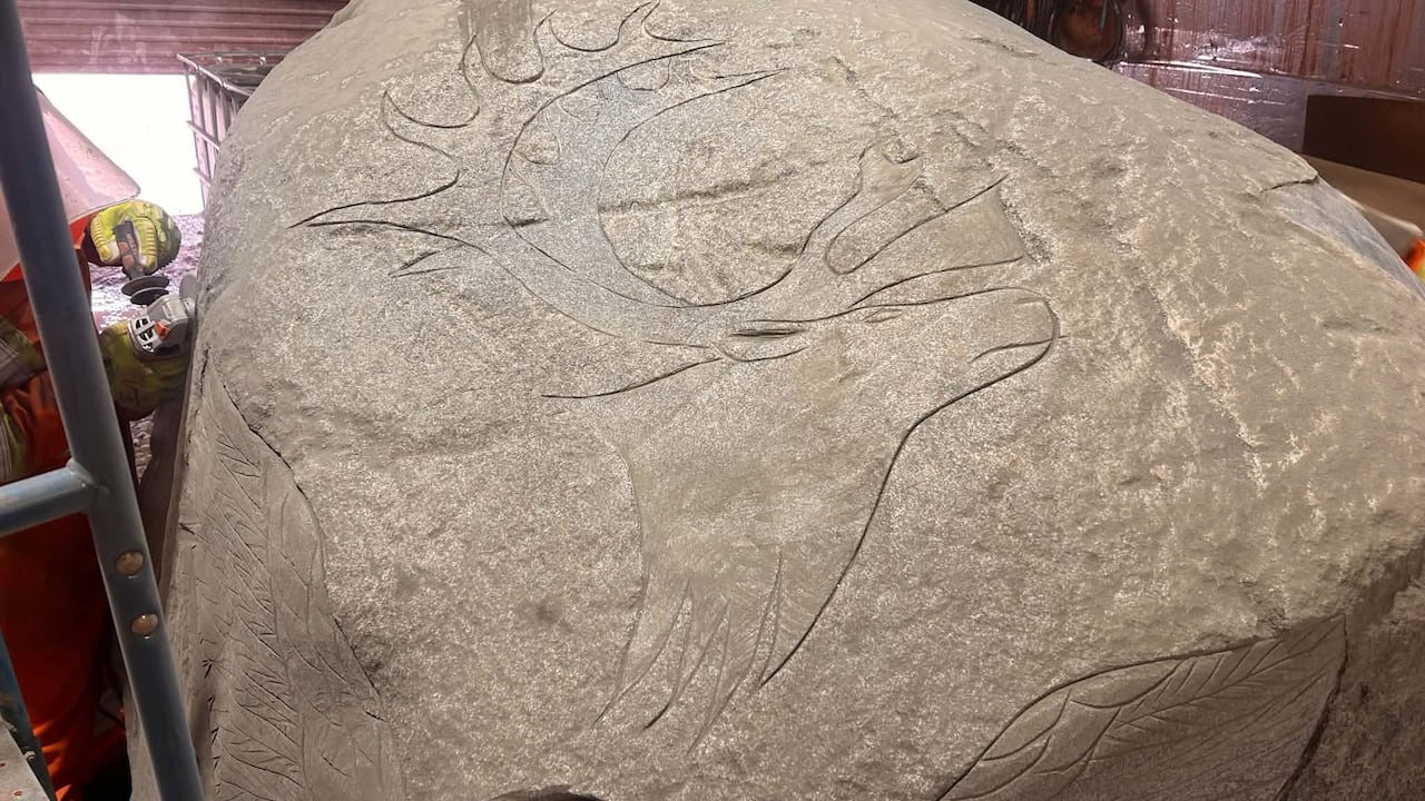 Moose carving on side of a boulder.