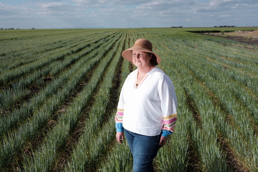 a woman stands in a green crop