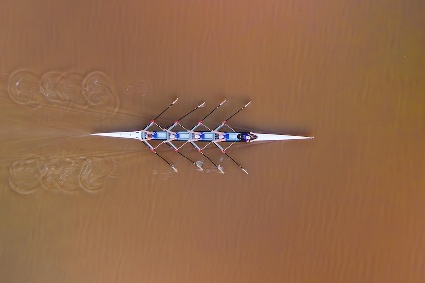 A drone shot of a rowing boat on a river.