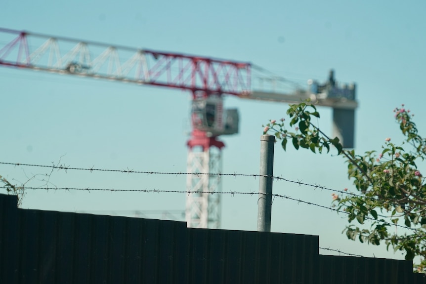 A Bathla Group crane with barbed wire in foreground. 