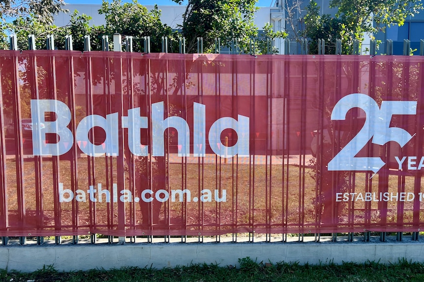 A red sign of Bathla at a construction site. 