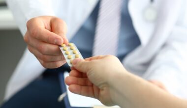 white-coated professional passing a pill pack to an outstretched hand