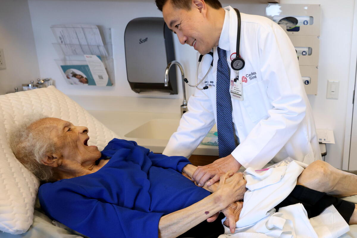 a doctor speaks with his patient in a hospital bed