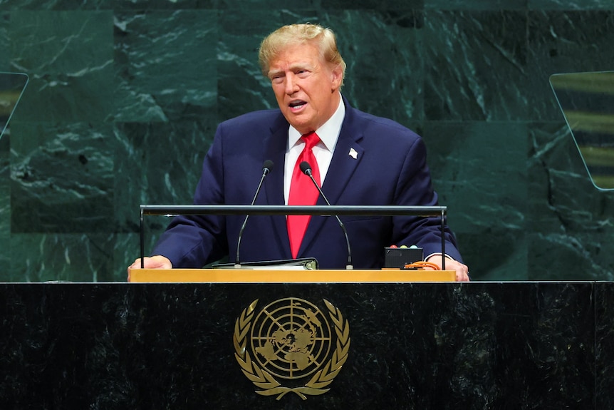 Donald Trump speaks at a lectern in the UN general assembly hall.