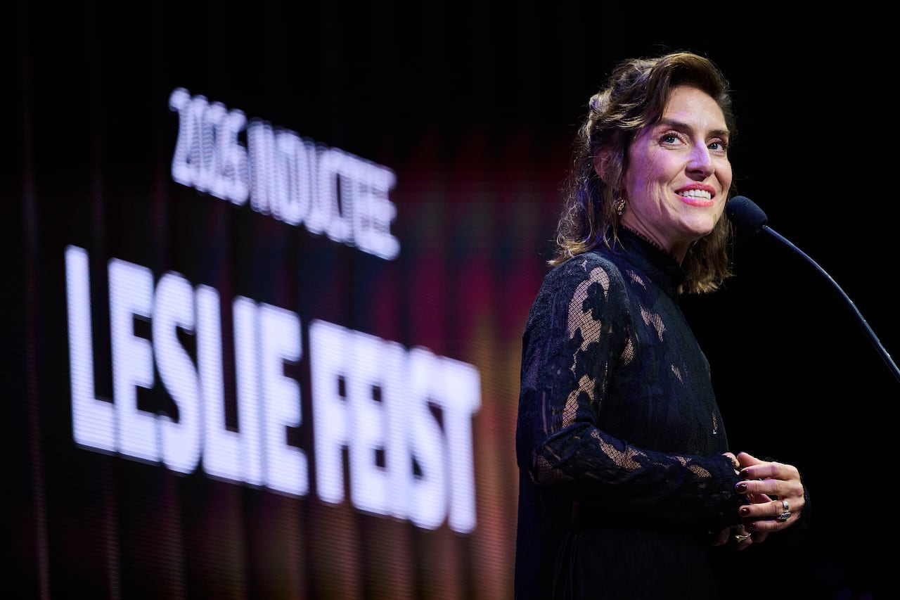 A woman stands, smiling, behind a podium