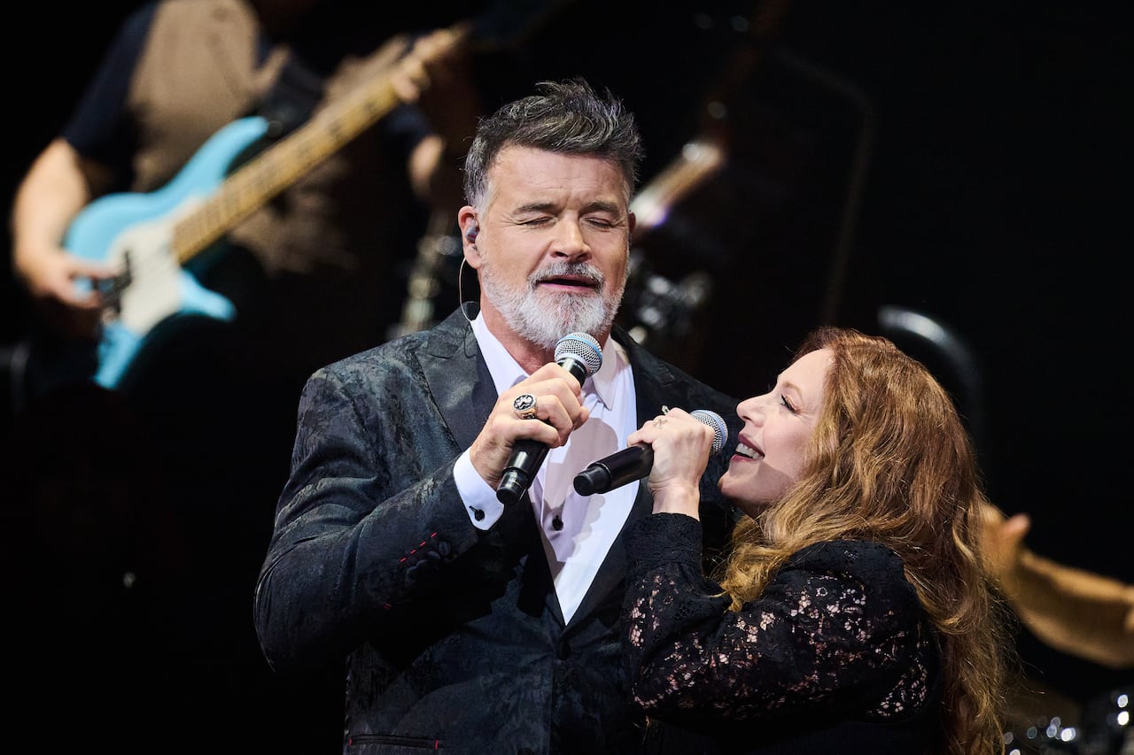 A man and a woman sing together on stage