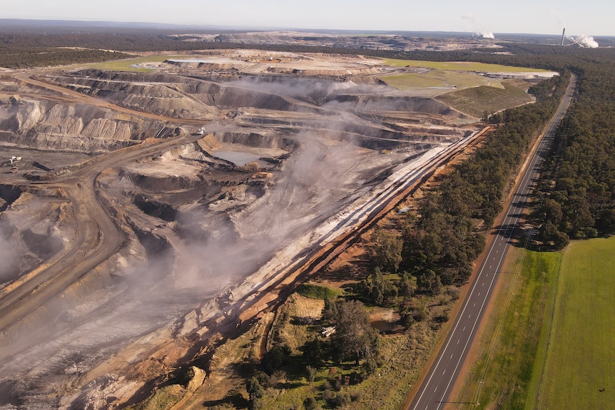 A huge coal pit near a country highway, as seen from the air.