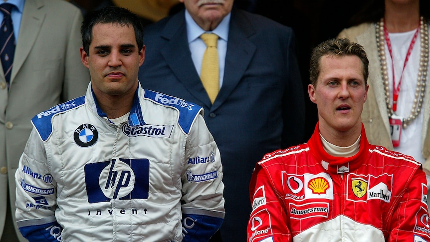 Juan Pablo Montoya of Colombia and Williams stands on the podium with Michael Schumacher of Germany and Ferrari