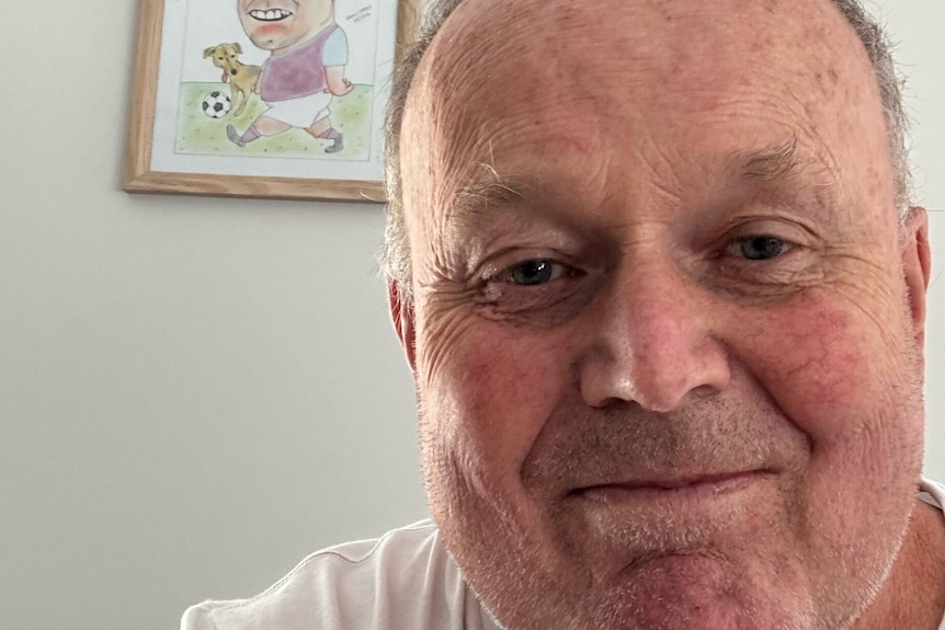 A close-up shot of a man with a neutral expression looking at the camera.