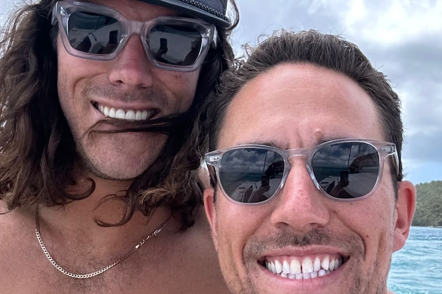 Two young men in sunglasses smiling