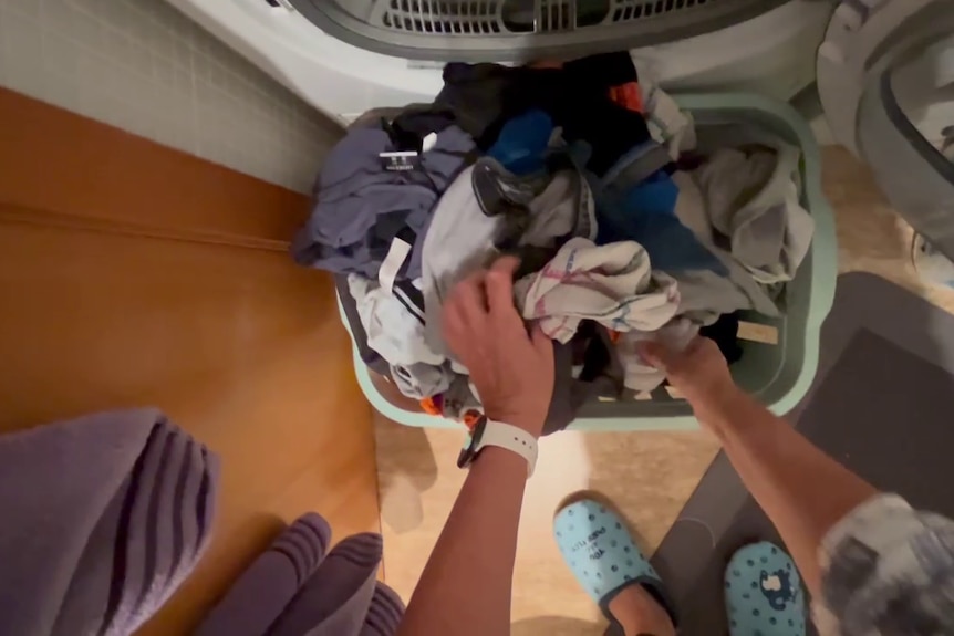 A still from a third-person video of someone doing laundry.