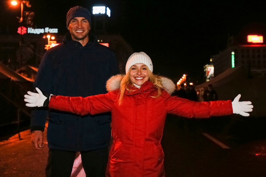Two smiling people in winter clothes pose for the camera