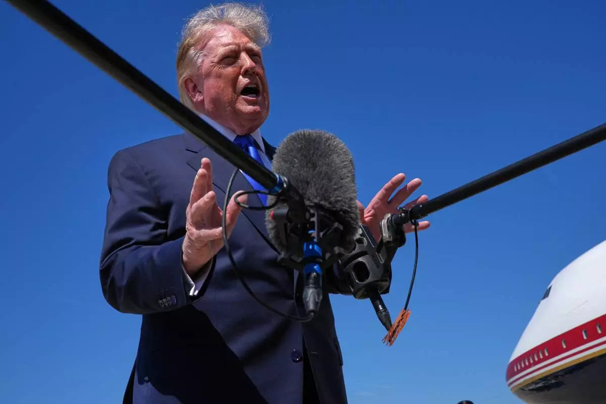 President Donald Trump talks with reporters after an emergency inflatable slide deployed on Air Force One before before Trump arrived to board at Joint Base Andrews, Md., Wednesday, Sept. 9, 2026. (AP Photo/Jacquelyn Martin)