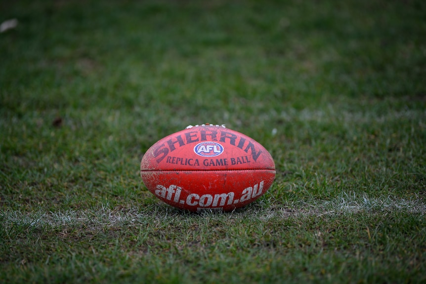 A worn red AFL Sherrin branded football
