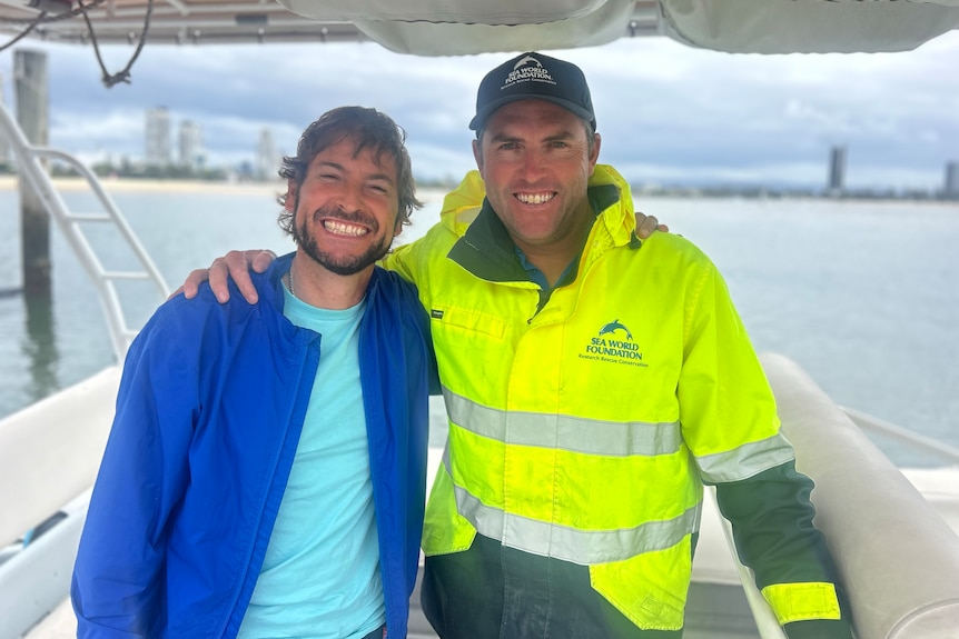Two men hugging and smiling.