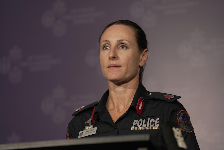 Janelle Tonkin, a woman with her hair tied back wearing a navy police uniform looks slightly to the right