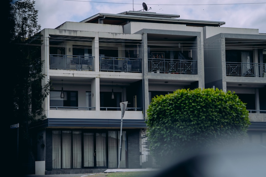 A grey block of units on a cloudy day