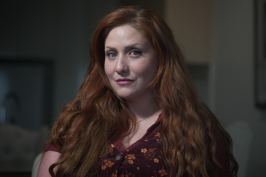A headshot of a woman unsmiling with red hair