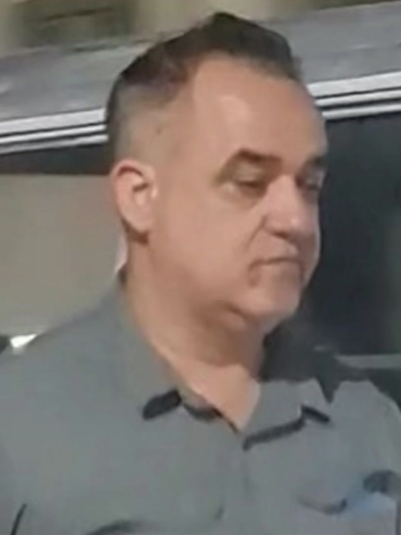 a blurry image of a man in a grey collared shirt