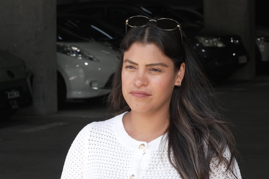 A woman with dark hair wearing a white t-shirt