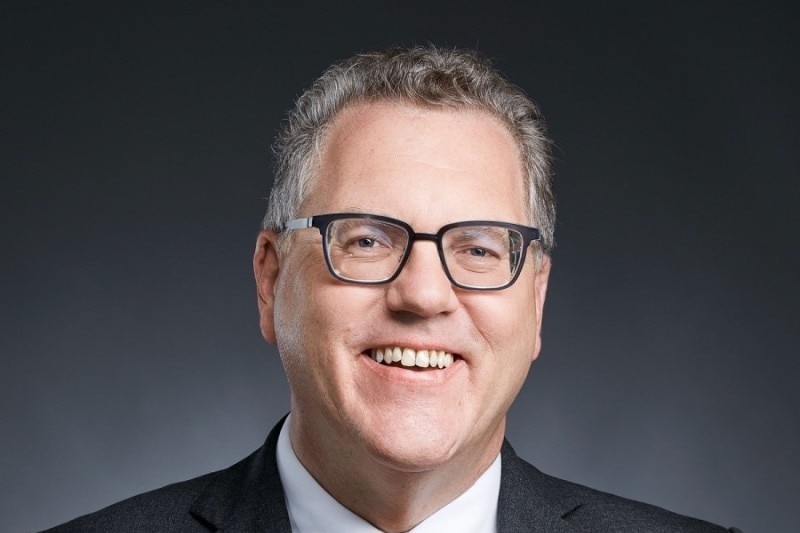 A middle aged man in a suit with glasses