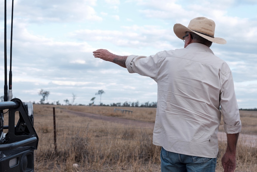 a man points to a paddock