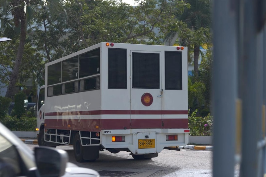 A prison van driving on a road.