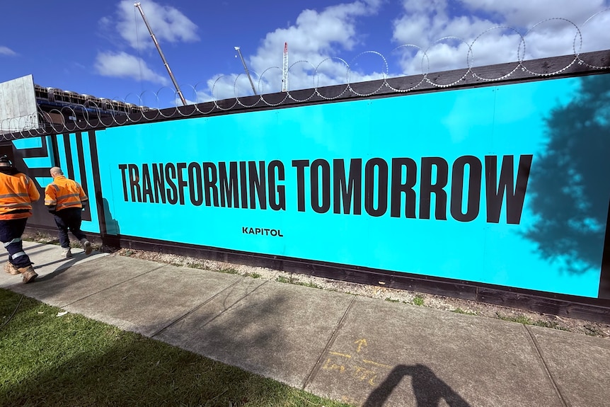 A construction wall at the NEXTDC data centre that says "transforming tomorrow".