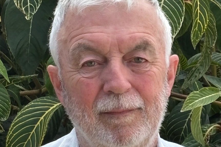 A man with white hair and a white short beard.
