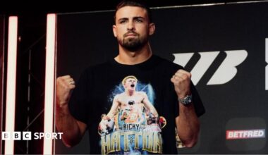 John Hedges holds up his fists and is wearing a black t-shirt with images of Ricky Hatton printed on it