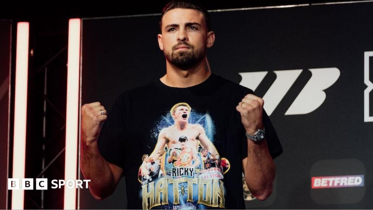 John Hedges holds up his fists and is wearing a black t-shirt with images of Ricky Hatton printed on it
