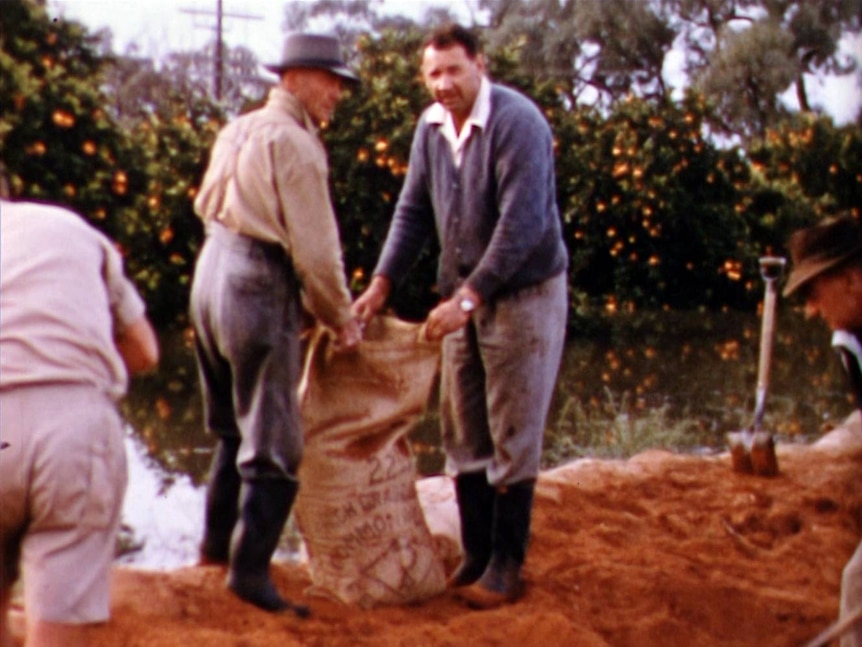 two men filling sandbags