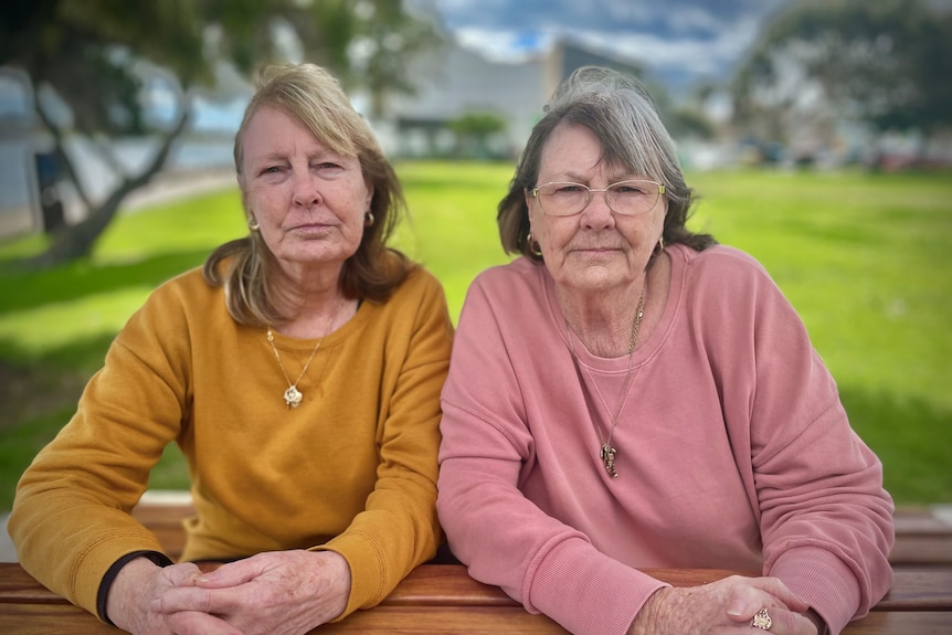 Two Crows supporters sitting at a park bench.