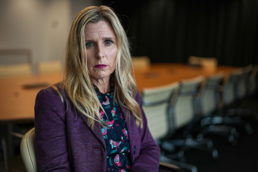 A portrait of Simone Constant in a boardroom with a solemn expression.