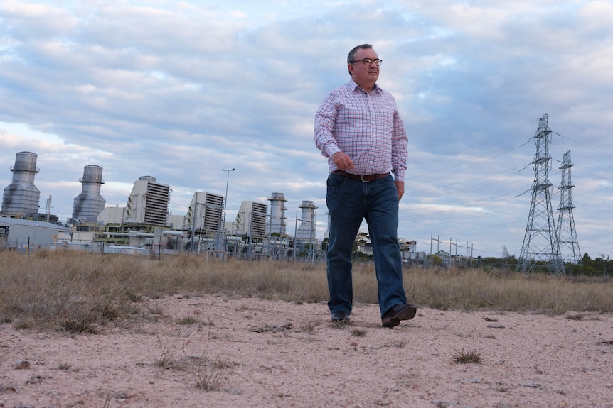 a man walking in front of a power plant