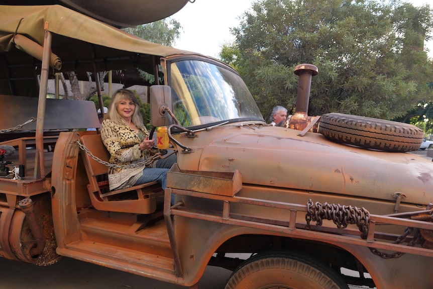 A woman, Delvene Delaney, sitting inside an old truck which once featured in the original Crocodile Dundee film.