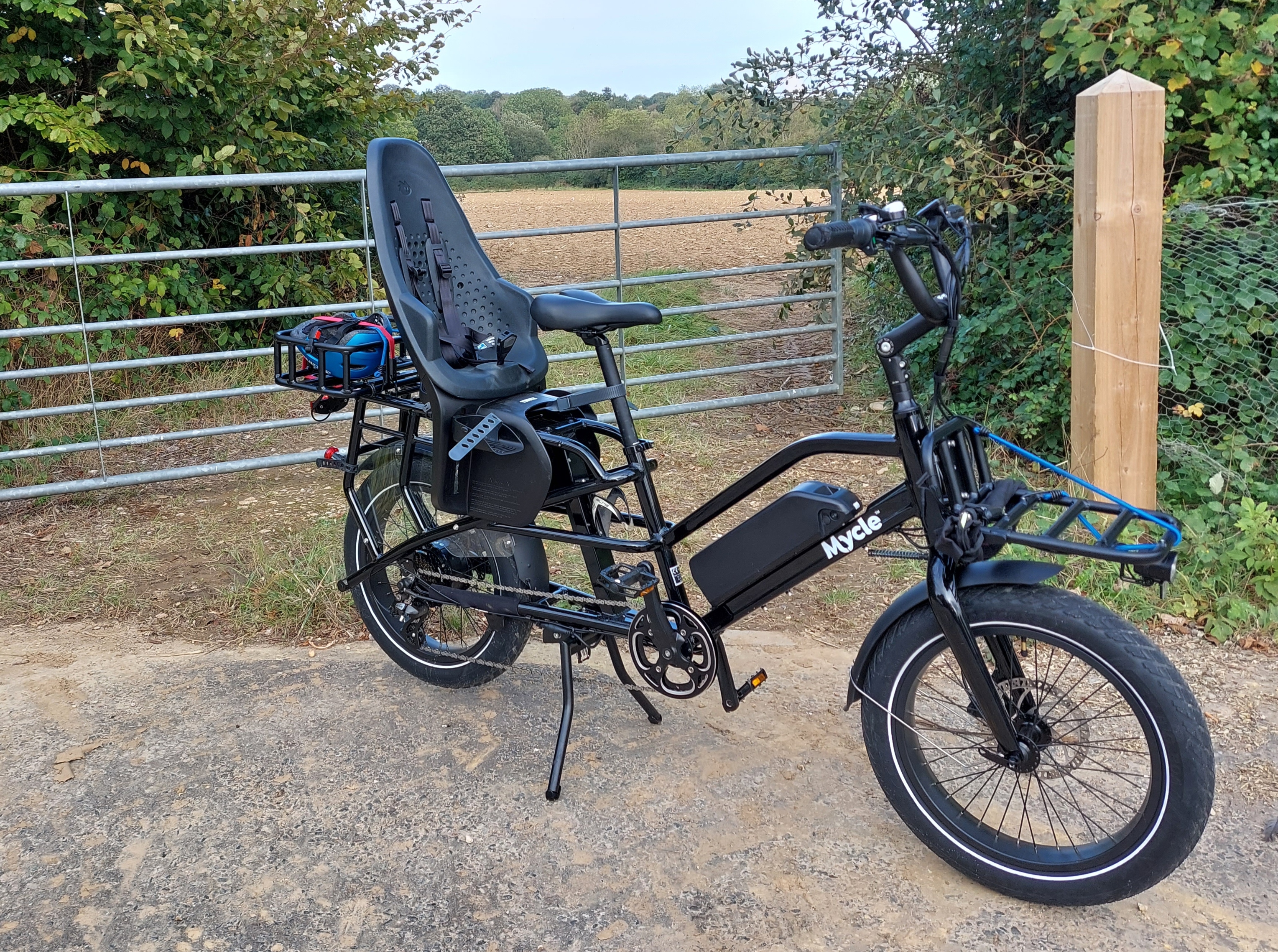 Mycle cargo bike parked by a rural gate