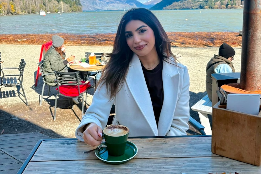 Kriti Sethi sits at a cafe in new zealand drinking coffee