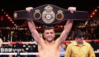 Jack Catterall holds a belt above his head in the ring