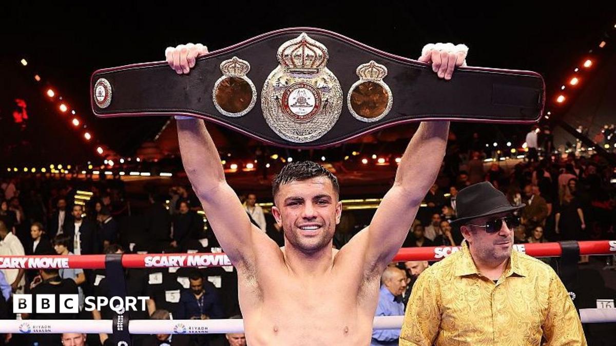 Jack Catterall holds a belt above his head in the ring