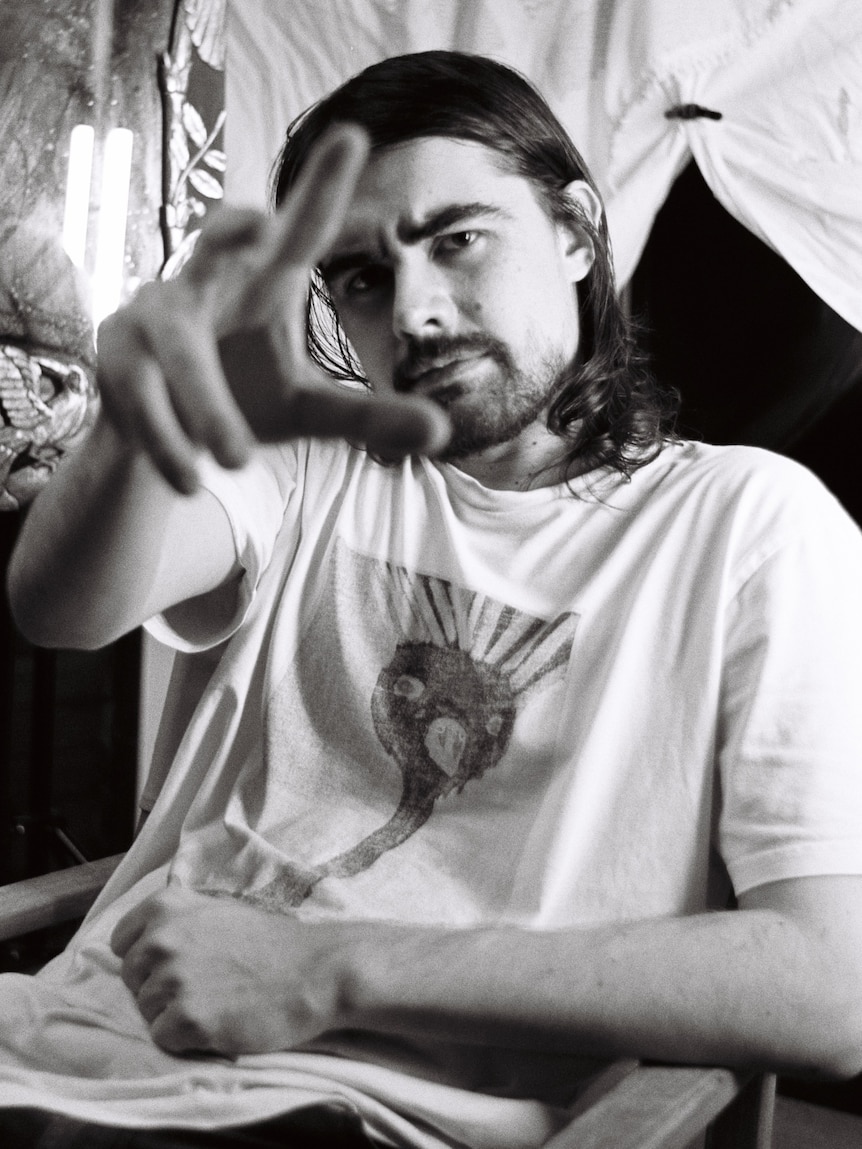 A man reaches his hand towards the screen.