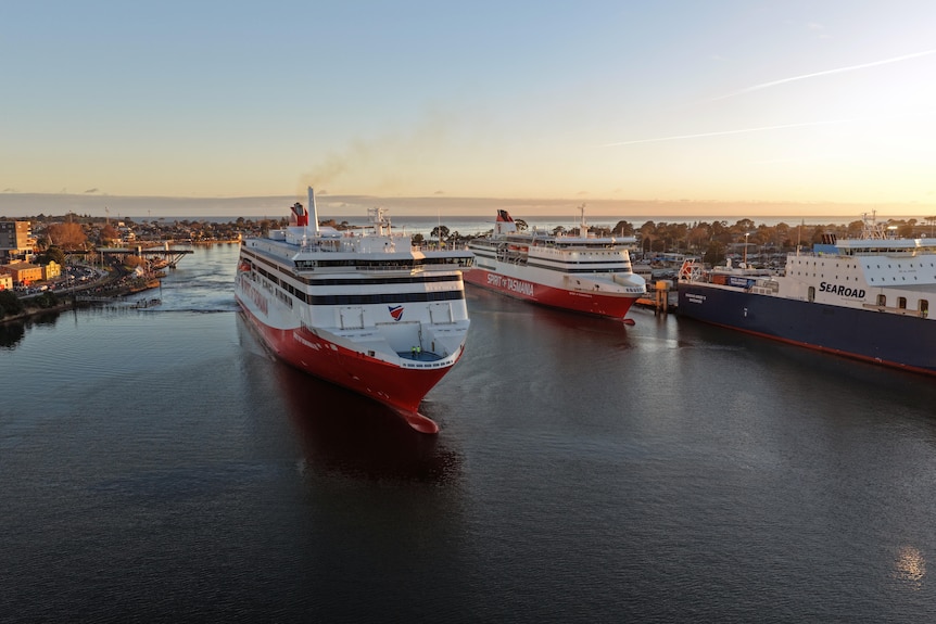 View of a new Spirit of Tasmania ferry passing one of the older Spirit ferries that is docked.
