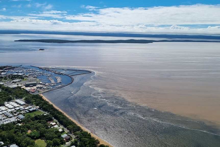 A line of clean water and dirty water off the coastline.
