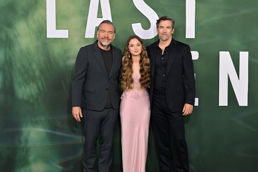 Brendan Cowell, 50, Chloe Jean Lourdes, a teenager, and Patrick Brammall, 50, pose in front of the Last Seen media wall.