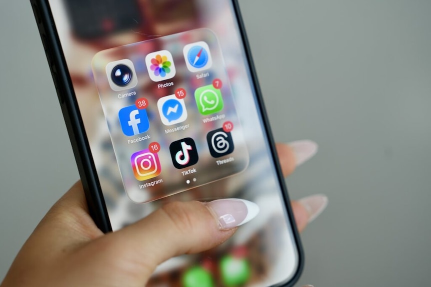 Woman's Hand Holding Phone with social media applications on screen