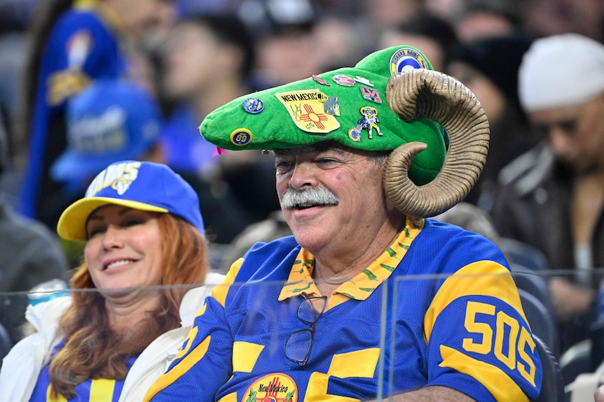 A Los Angeles Rams fan in a hat shaped like a Ram's skull